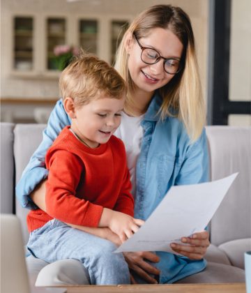 Mother and toddler reviewing documents together, illustrating family support in financial decisions related to commercial finance options.